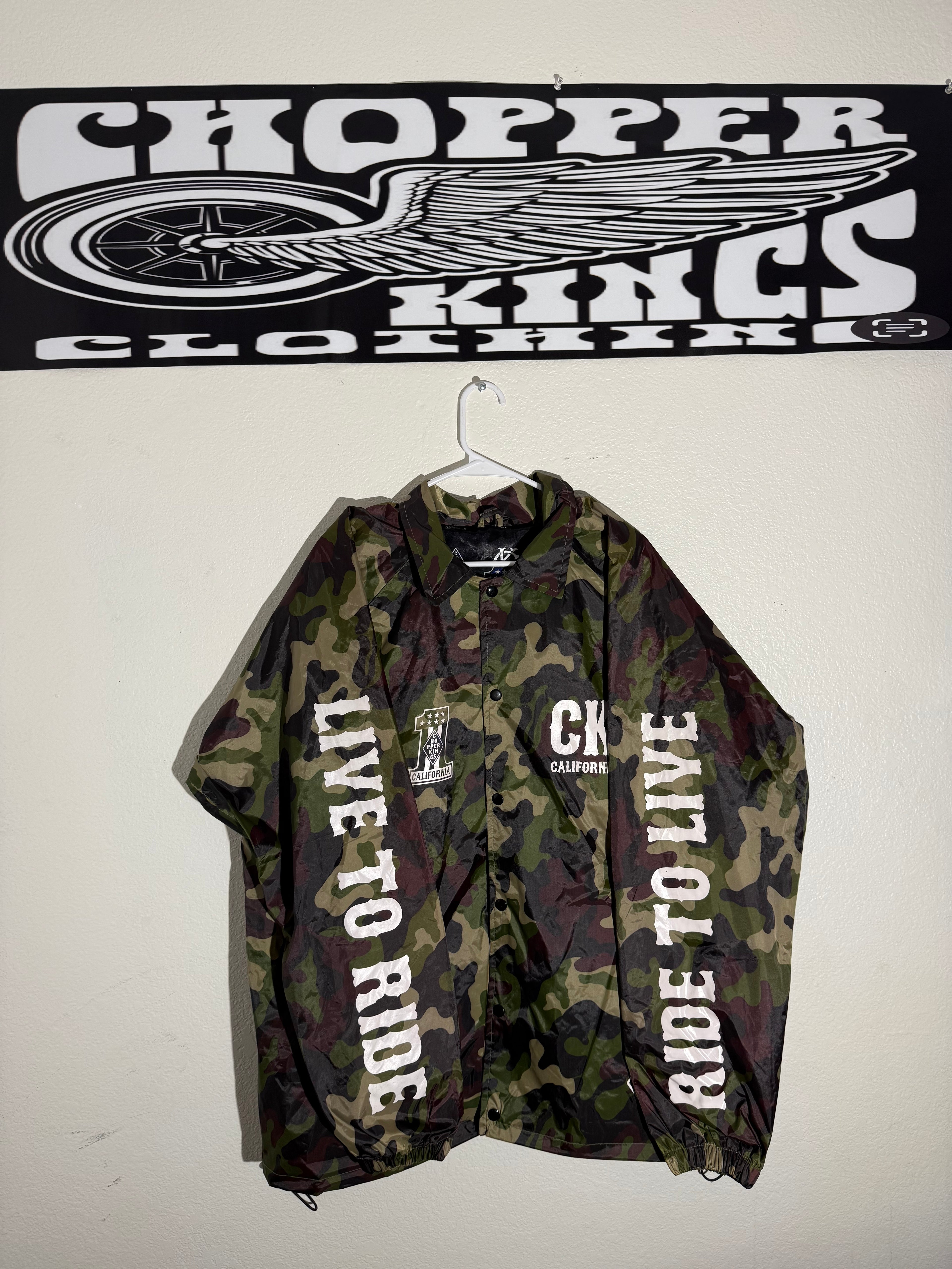 Camouflage jacket with 'Ride to Live' text next to a 'Topper Cloths' logo on a white background