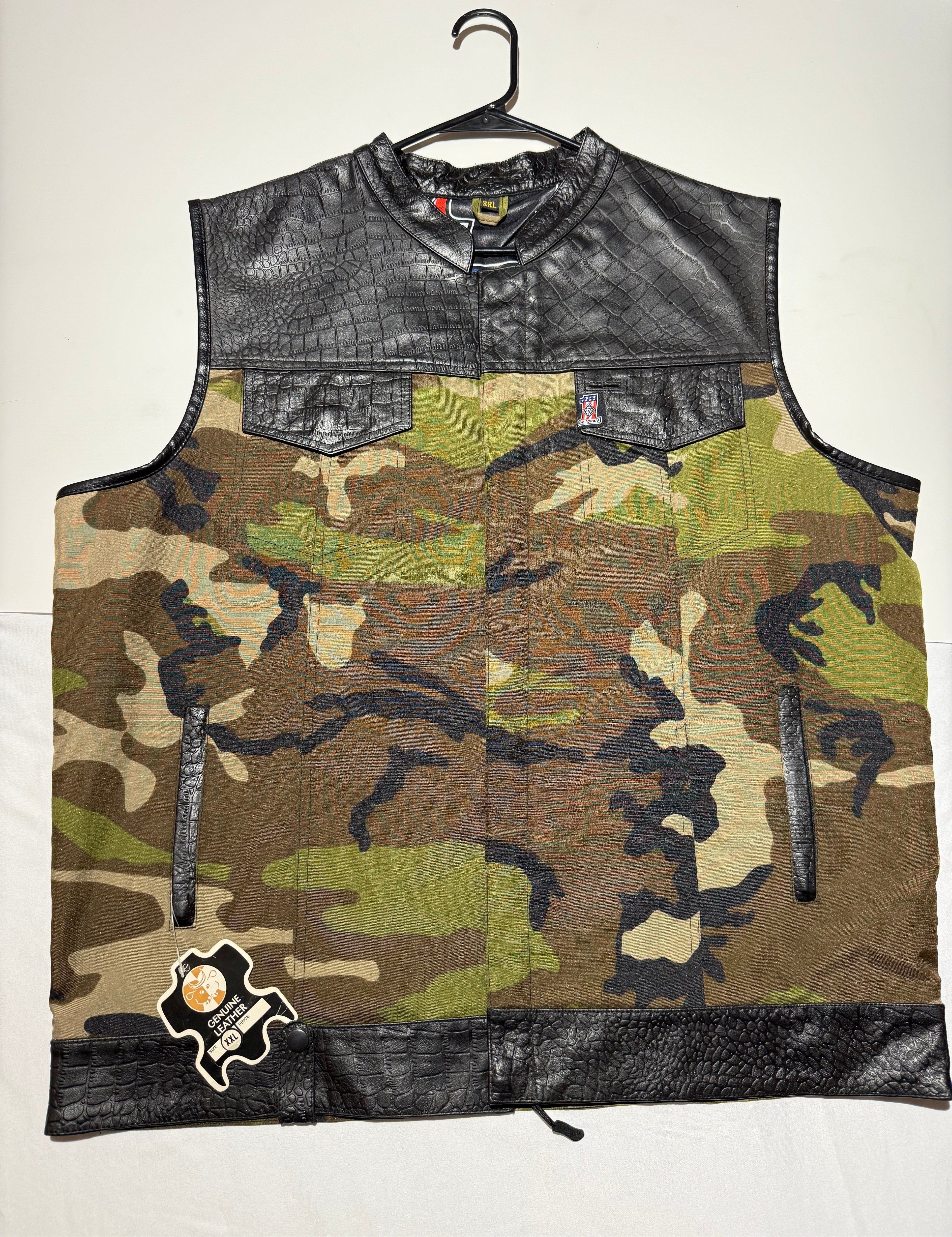 Camouflage-patterned vest with black leather accents on a white background