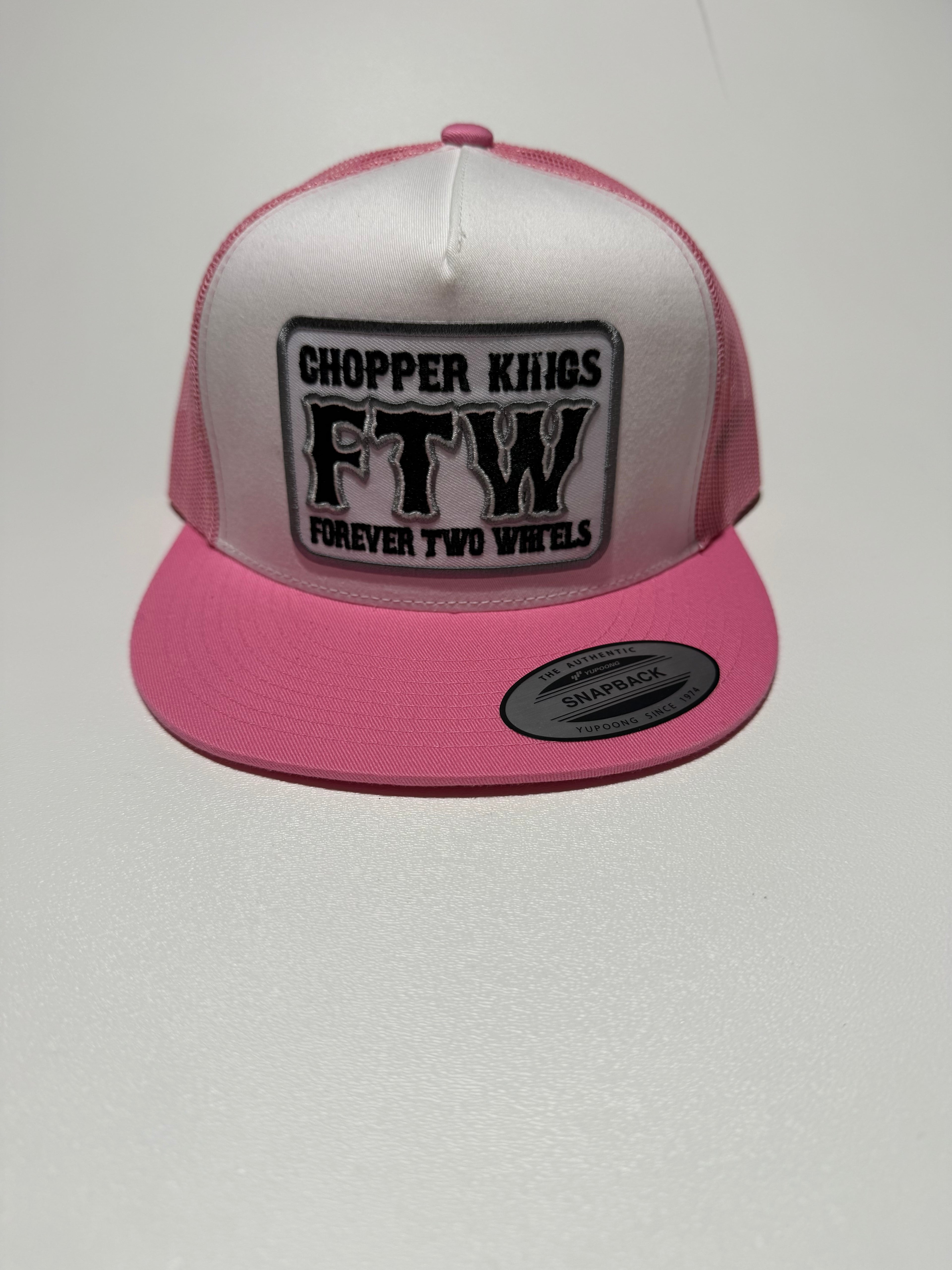 Pink and white cap with a black and white logo on a light gray background