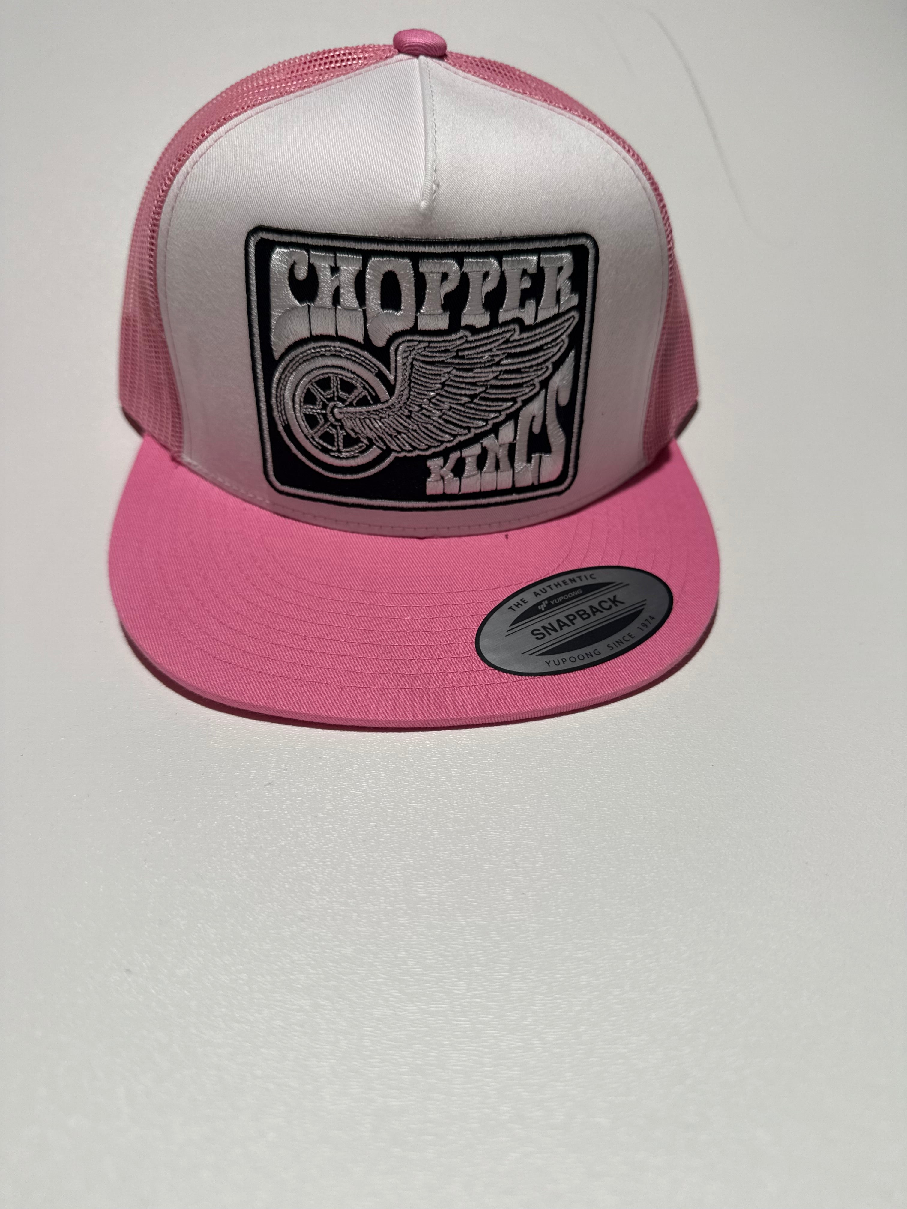 Pink and white cap with a logo on a light gray background