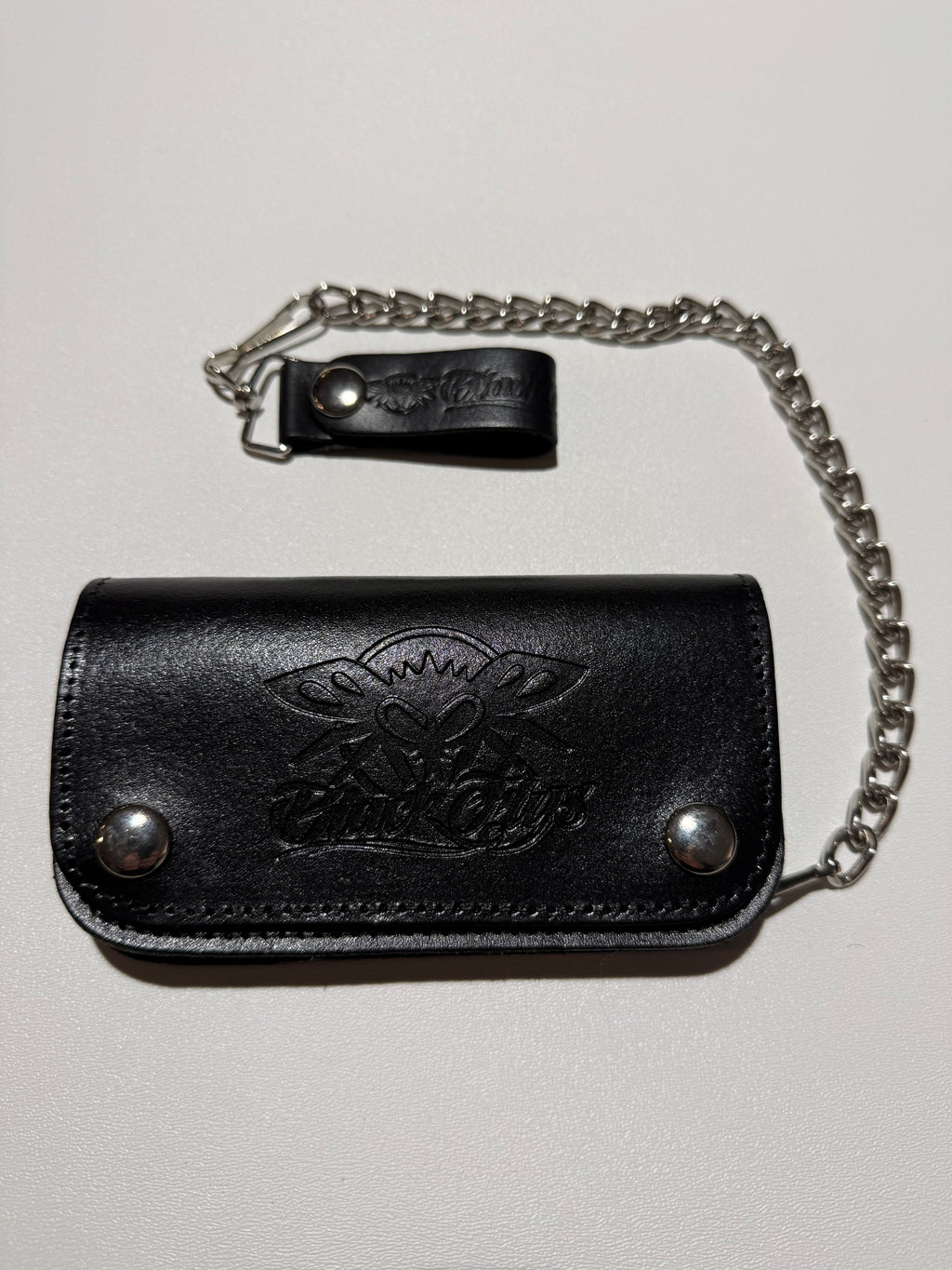 Black leather key holder with chain on a light gray background