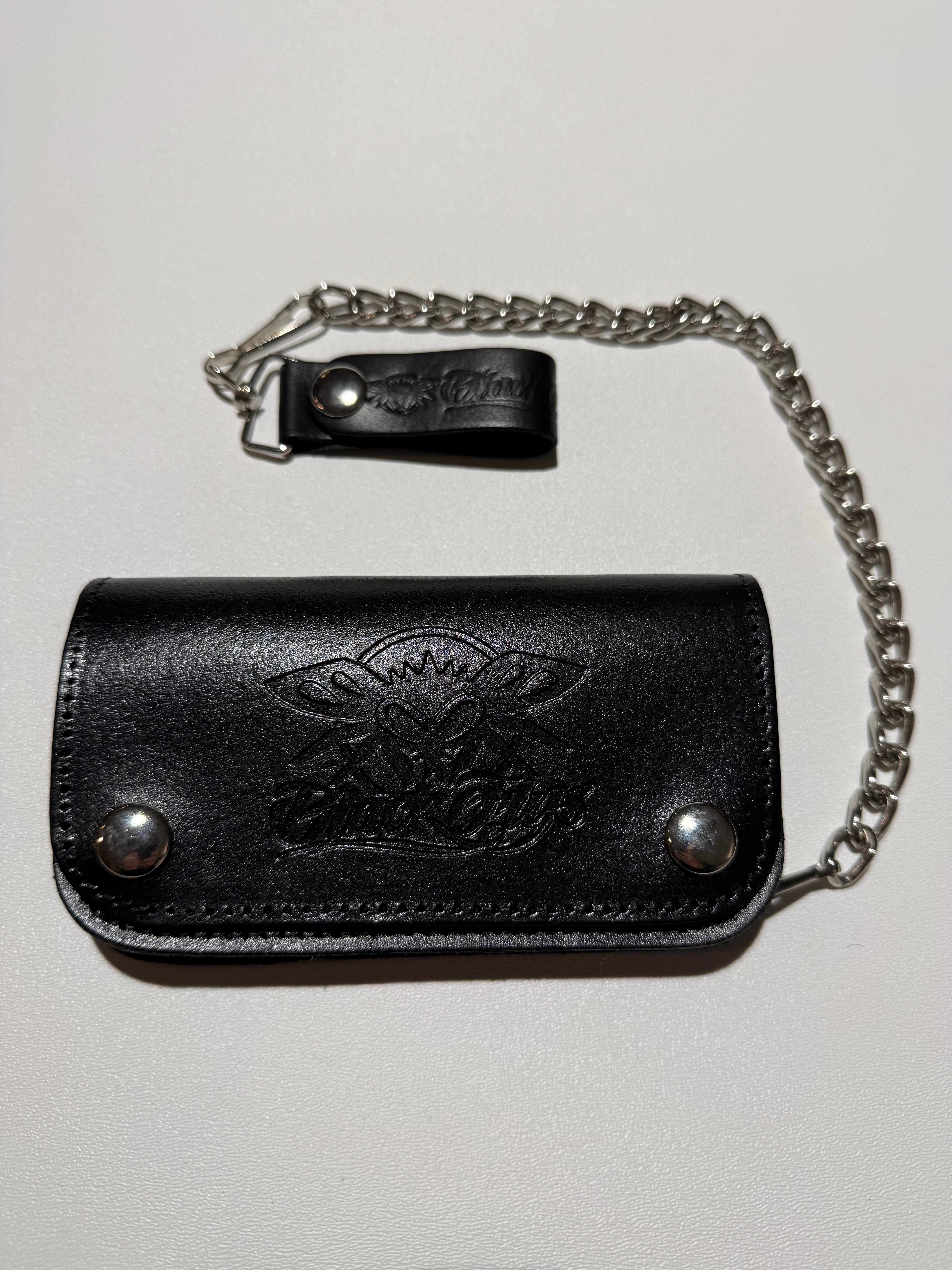 Black leather key holder with chain on a light gray background