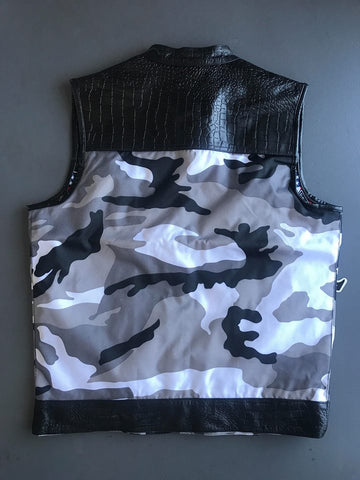 Camouflage-patterned vest with black leather accents on a gray background