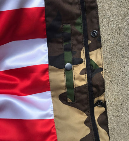 Close-up of a jacket with camouflage pattern and American flag design.