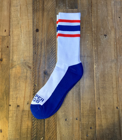 White sock with blue toes and red and blue stripes on a wooden surface