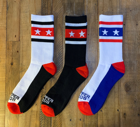 Three pairs of socks with star patterns on a wooden surface