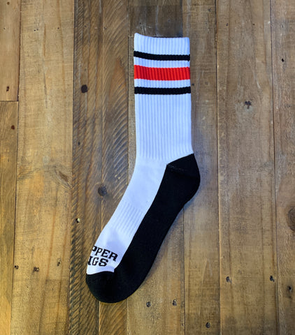 White sock with black and red stripes on a wooden surface