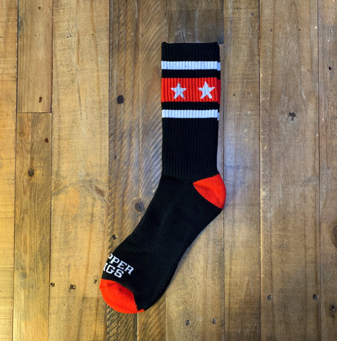 Black sock with red and white accents on a wooden surface