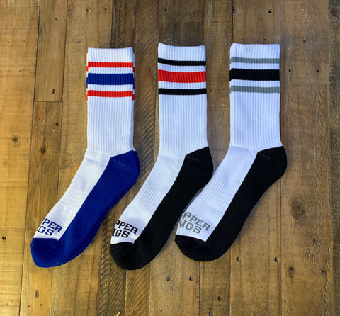 Three pairs of socks with colored stripes on a wooden surface