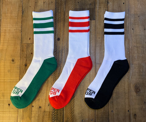 Three pairs of socks with striped patterns on a wooden surface